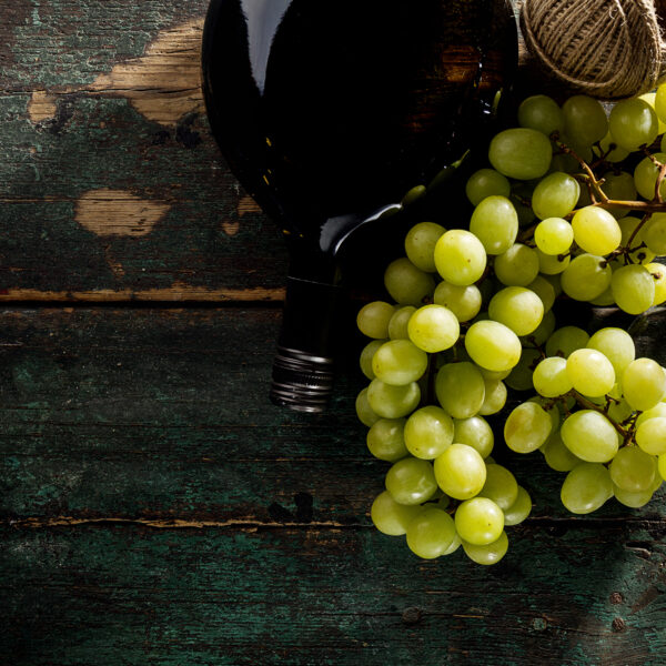 Tasty Fresh Green Grape with Wine Bottle and Wine Glass Red Wine on Old Green Vintage Background Top View Horizontal Copy Space